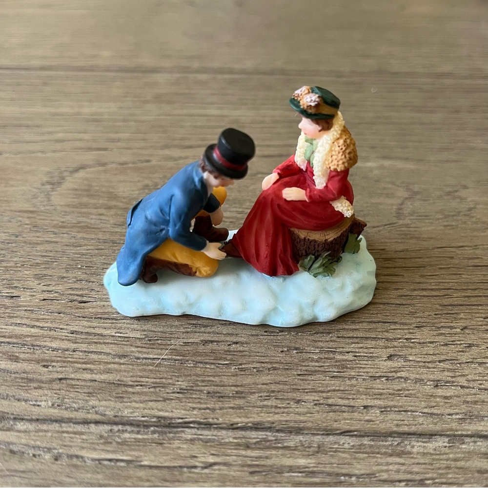 O’Well’s Christmas Village Figurine depicting- Man & Woman Tying Skates